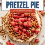 A strawberry pretzel pie topped with whipped cream, fresh strawberries, and pretzels.
