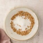 A bowl of sugar with chopped pretzels around the edge.