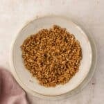 Chopped pretzels in a bowl on a light background.
