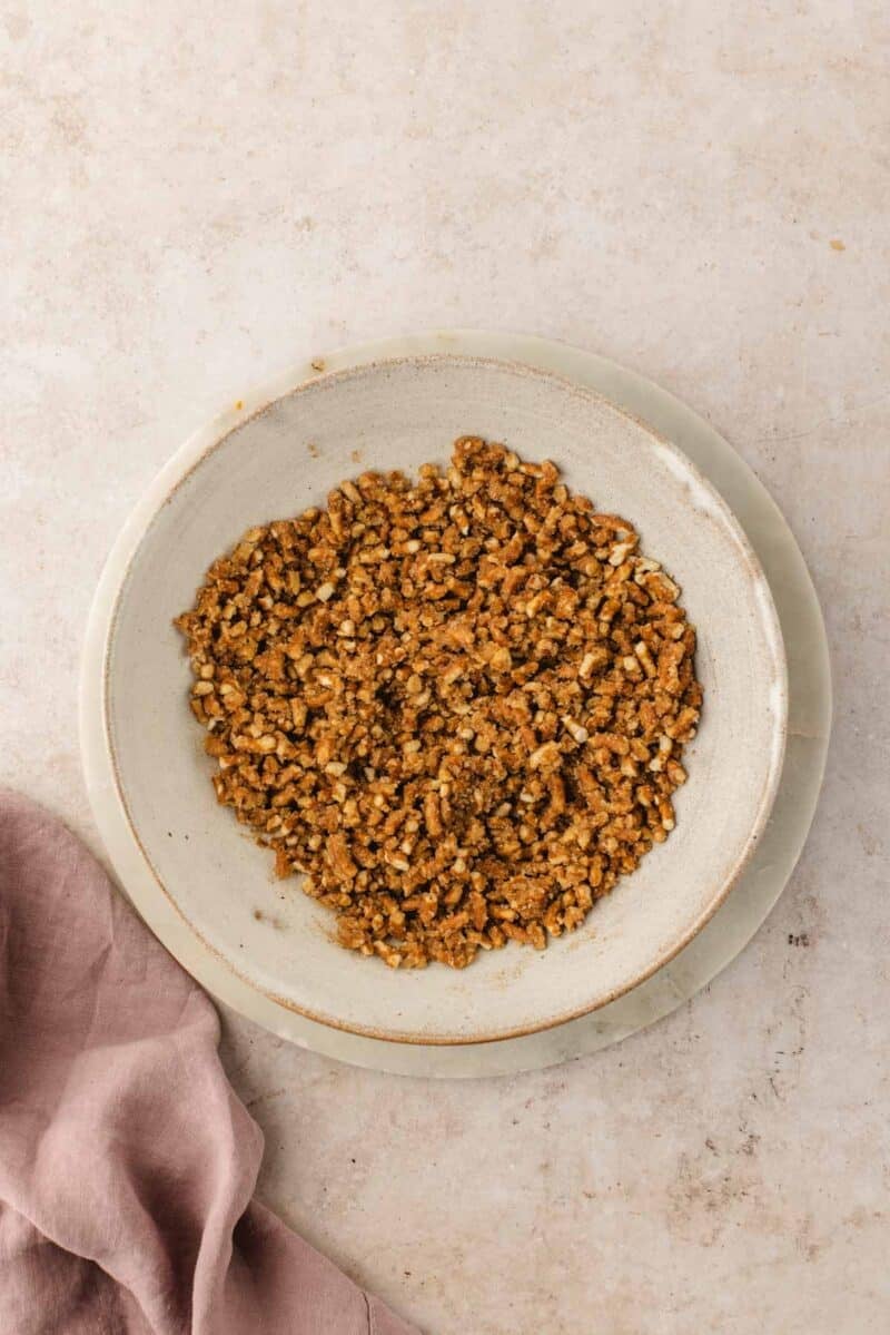 Chopped pretzels in a bowl on a light background.