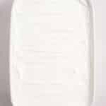 A rectangular white baking dish filled with a smooth, evenly spread layer of white whipped topping.