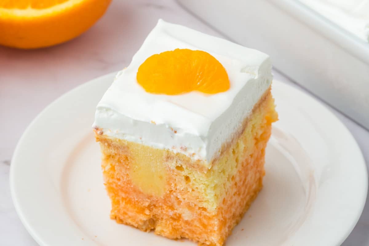 Orange creamsicle poke cake—boxed mix with fresh orange juice, orange Jello, creamy vanilla pudding,