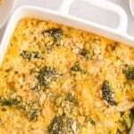 A baked chicken broccoli rice casserole, and crumbled crackers in a white dish, viewed from above.