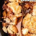 A wooden spoon scoops caramel apple cobbler from a skillet, showing baked apples and biscuit topping. The text reads “Caramel Apple Cobbler” at the top and “Southern” at the bottom.