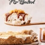 A slice of no-bake apple cheesecake with graham cracker crust and caramel sauce is lifted from a whole cheesecake on a plate.