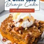 A square of pumpkin dump cake topped with whipped cream, caramel sauce, and pecans on a white plate. Text overlay reads: āPUMPKIN Dump Cake, GET THE RECIPE ON THE BLOG.ā
