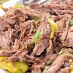 Shredded mississippi pot roast with yellow pepperoncini peppers and fresh herbs.